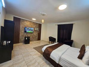 a hotel room with a bed and a flat screen tv at الرموز الصادقة للشقق المخدومة Apartments alrumuz alsadiqah in Jeddah