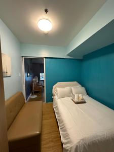 een kleine kamer met een bed en een bank bij Azure Urban Resort Staycation Miami Tower near NAIA with wifi and Netflix - Js Haven in Manilla