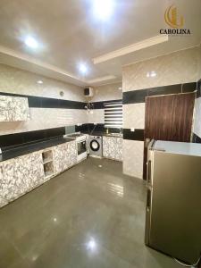 una gran cocina con nevera en una habitación en Carolina Apartments Wuye, en Abuja