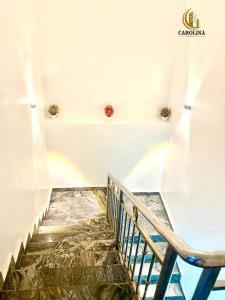 una escalera en una habitación blanca con escalera en Carolina Apartments Wuye, en Abuja
