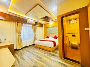 a hotel room with a bed and a bathroom at Hotel Ultra International in Bhairāhawā