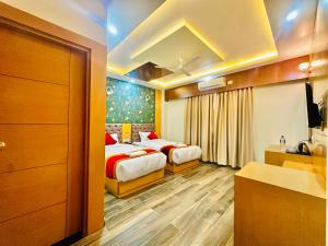 Cette chambre comprend deux lits et une salle de bains. dans l'établissement Hotel Ultra International, à Siddharthanagar