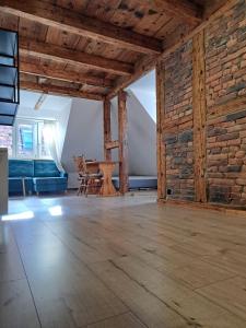 an empty room with a table and a brick wall at Górskie apartmenty Kowary in Kowary