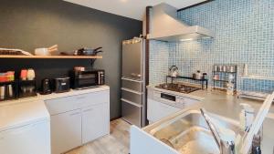 a kitchen with a sink and a counter top at QUENOS in Oshima