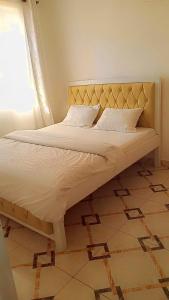 un letto con testiera e cuscini in una camera da letto di Serene Safaris Airbnb in Thika a Thika