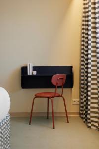 a red chair sitting in front of a desk at Hotel des Victoires - Restaurant in Cannes