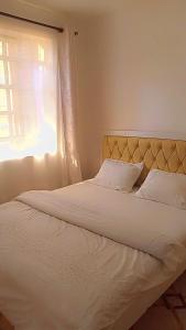 una camera con un letto bianco e una finestra di Serene Safaris Airbnb in Thika a Thika