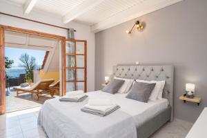 um quarto com uma cama grande e um pátio em Southbank seafront apartments em Kateleios