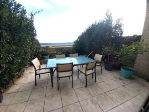 een blauwe tafel en stoelen op een patio bij La villa d'Evalou in Calvisson