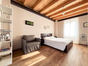 ein Schlafzimmer mit einem Bett und einem Stuhl in der Unterkunft RIAREL- Foresteria Lombarda in Rodero