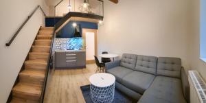 カールスボリにある2. Apartmán na Faře mezonetのソファと階段のあるリビングルーム