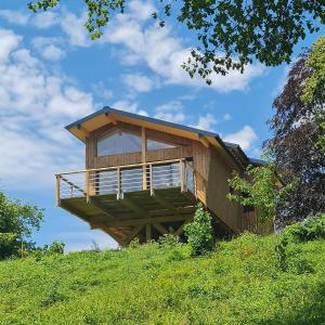 a house on top of a grassy hill at Cabanes du Domaine des Fées in Dole