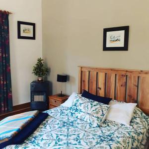 a bedroom with a bed with a wooden head board at Frosty Peaks Farmstay in Barkly East
