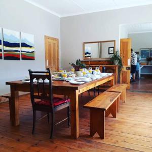a wooden dining room table with chairs and a dining room at Frosty Peaks Farmstay in Barkly East
