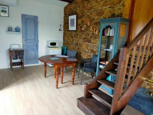 een woonkamer met een houten tafel en een trap bij La Verdine in Vérin