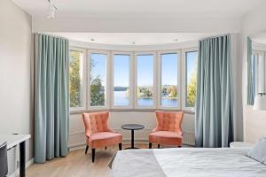 a bedroom with two chairs and a table in front of windows at Original Sokos Hotel Seurahuone Savonlinna in Savonlinna +74 photos