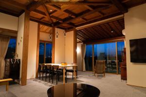 a dining room with a table and chairs with a view at 十八楼離れ 宿いとう in Gifu