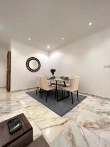 uma sala de jantar com mesa e cadeiras em Luxurious Apartment Partial Sea View em Jeddah