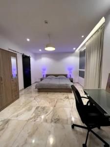 Luxurious Apartment Partial Sea View في جدة: غرفة نوم رئيسية بسرير ومكتب ومكتب
