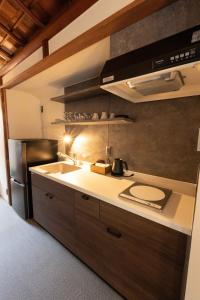 a kitchen with a sink and a refrigerator at 十八楼離れ 宿いとう in Gifu