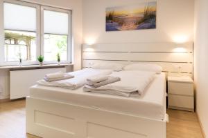 a large white bed in a room with two windows at Feriendorf Slawitsch in Bad Sulza