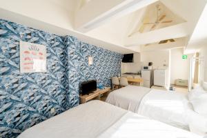 - 2 lits dans une chambre avec papier peint bleu et blanc dans l'établissement ILIMA Higashi Nakano 新宿から電車で5分 東中野駅まで徒歩2分 最大4人 洗濯機 ダイニングキッチン 電子レンジ, à Tokyo