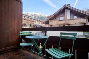 a table and two chairs on a balcony with a view at Oberstdorfer Ferienwelt am Marktplatz in Oberstdorf