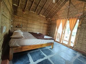 een bed in een kamer met een groot raam bij Rasta Cafe Hmpi in Hampi