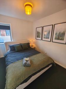 ein Schlafzimmer mit einem Bett mit zwei Handtüchern darauf in der Unterkunft Beautiful house near everything! in Christchurch