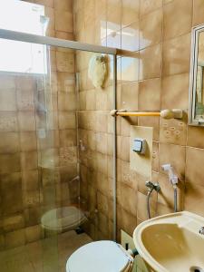 W łazience znajduje się prysznic, toaleta i umywalka. w obiekcie Ap férias - 2 qt - Wi-Fi - Guarapari - Praia do Morro w mieście Guarapari