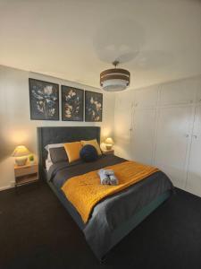 Un dormitorio con una cama grande con un animal de peluche. en Beautiful house near everything! en Christchurch
