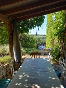 a table and chairs sitting under a pergola at Gite Les Volets Bleus du Segur in Le Ségur-Suech