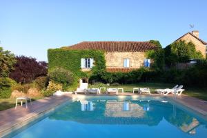 a villa with a swimming pool in front of a house at Gite Les Volets Bleus du Segur in Le Ségur-Suech
