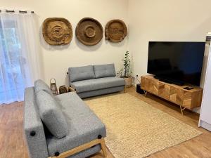 ein Wohnzimmer mit einem Sofa und einem Flachbild-TV in der Unterkunft Tranquil holiday home on the water’s edge. in Rainbow Beach