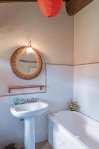 uma casa de banho com um lavatório, um espelho e uma banheira em Casale Pomodoro em Manziana