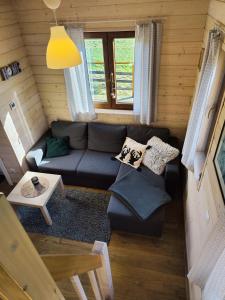 a living room with a couch and a table at Leśna Przystań - Domki całoroczne in Grywałd