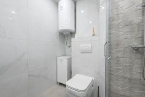een witte badkamer met toilet en douche bij Filip in Bar +6 foto's