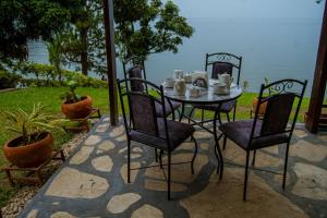 a table and four chairs with a table and a table and chairs at La Casa Nostra Rubavu in Rubavu
