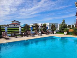 a large swimming pool with chairs at Casa OK by OVO in Vama Veche