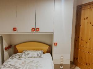 een slaapkamer met een bed en witte kasten bij Mansarda de Legn in Cannobio