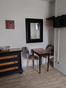 Habitación con mesa, sillas y espejo. en Ma Gentilhommière, en Croutoy