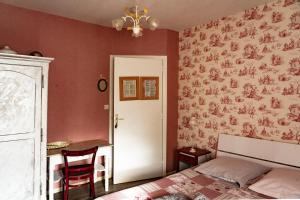 a bedroom with a bed and a table and a chandelier at Ma Gentilhommière in Croutoy