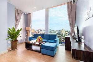 a living room with a blue couch and a large window at Khách sạn Bamboo Sài gòn in Ho Chi Minh City