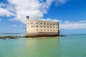 a building on a island in the water at Gîte des Bujours in Saint-Bris-des-Bois