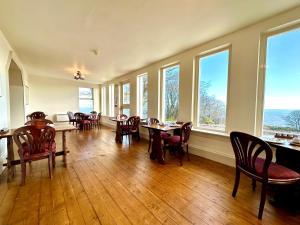 a dining room with tables and chairs and windows at Navidale House - Bed, Breakfast & Bar in Helmsdale