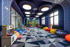 uma sala de jogos para crianças com paredes azuis e um piso xadrez em Wyndham Garden Burabay em Borovoye
