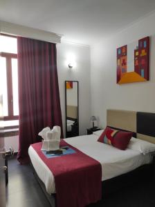una camera d'albergo con letto e specchio di Hotel Plebiscito Aparthotel a Napoli