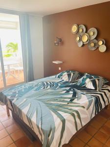 Schlafzimmer mit einem Bett mit einer Tagesdecke im tropischen Stil in der Unterkunft TI BONHEUR DE TARTANE in La Trinité