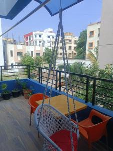 a porch with a hammock and a table on a balcony at The Palm Greens in Pune