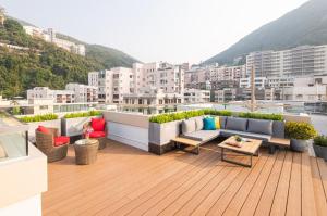 a balcony with couches and tables on a building at Eaton Residences, Blue Pool Road in Hong Kong